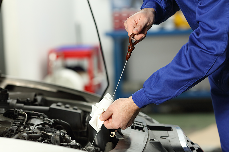 Technician working under car exhaust system